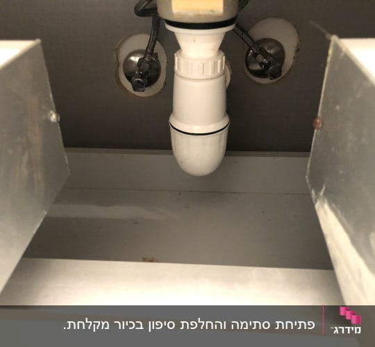 צינור ניקוז לבן מתחת לכיור עם חיבורים